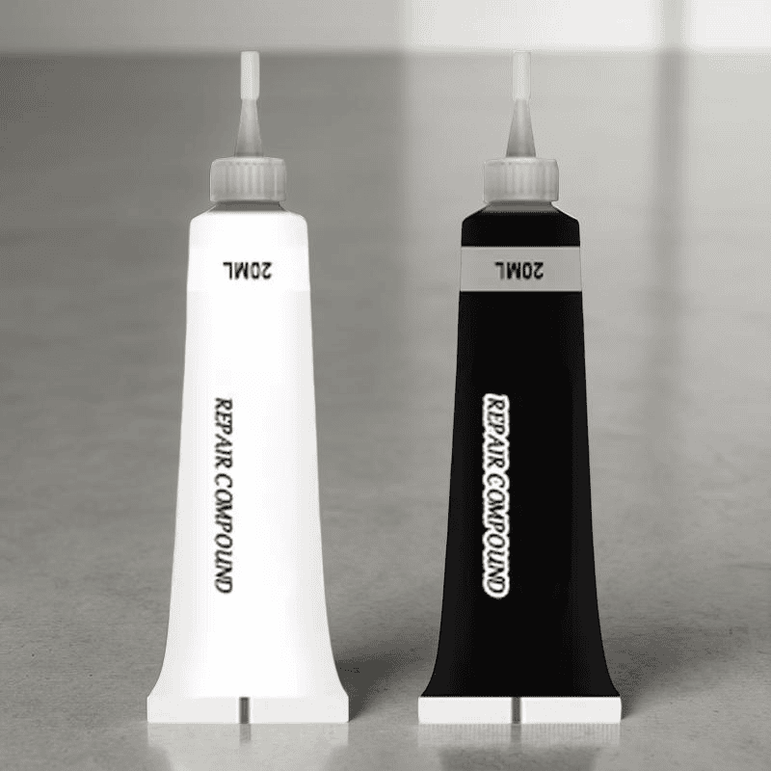 Two tubes of repair compound, one white and one black, on a gray surface.