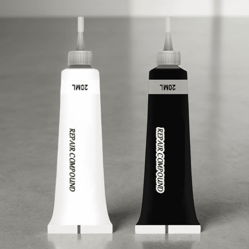 Two tubes of repair compound, one white and one black, on a gray surface.