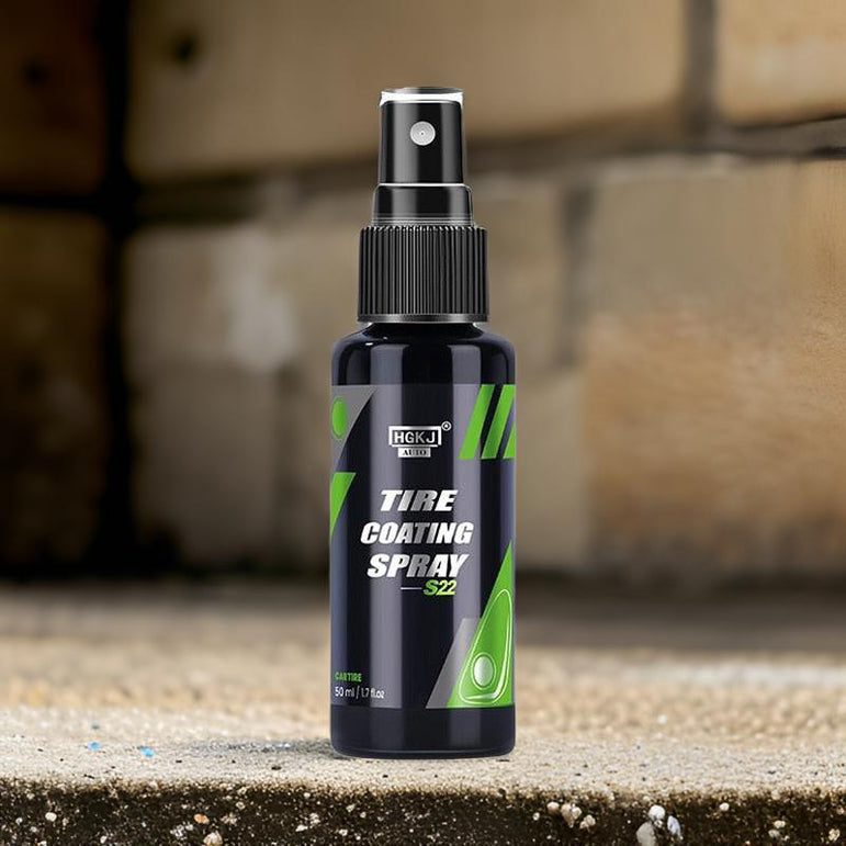 Bottle of tire coating spray on a concrete surface with a blurred brick wall background